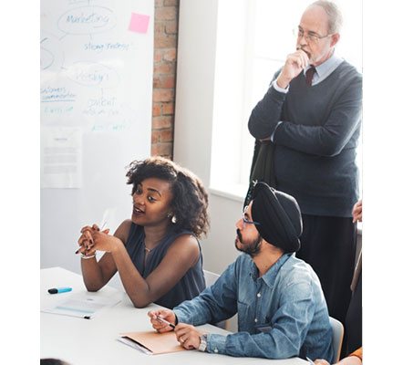 adults sitting during a meeting around a conference table