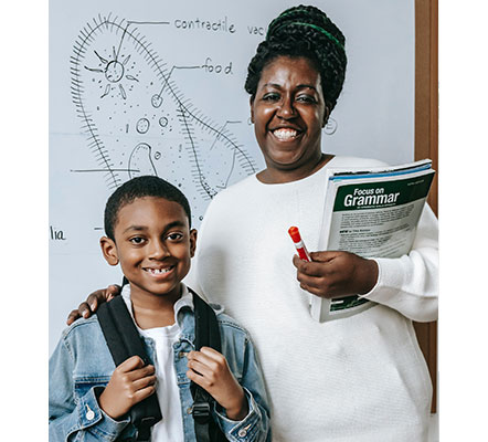 teacher and student in the classroom posing and smiling